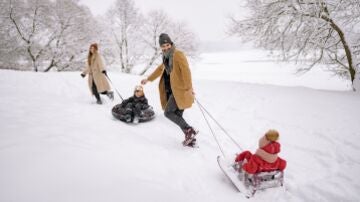 Familia con trineos en la nieve