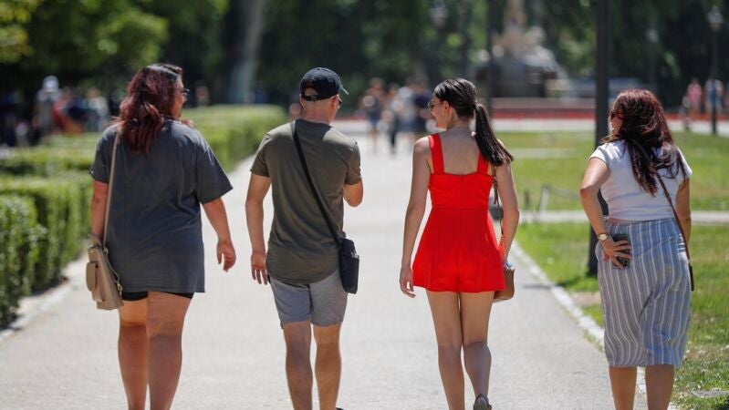 Varios jóvenes pasean por un parque de Madrid