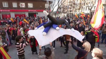 Manifestantes en la calle Ferra manteando dos muñecos que emulaban a Sánchez y Puigdemont