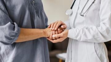 Dos mujeres agarradas de la mano, en apoyo contra el cáncer.