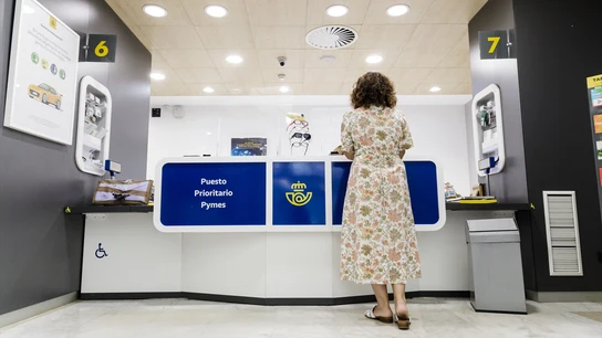 Una mujer es atendida en la oficina de Correos. Una mujer es atendida en la oficina de Correos.