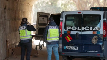 Dos agentes de la Policía Nacional aguardan bajo el Puente del Real en el lugar donde se ha encontrado a dos hombres muertos "con la cabeza reventada con heridas grandes" producidas por las pedradas.