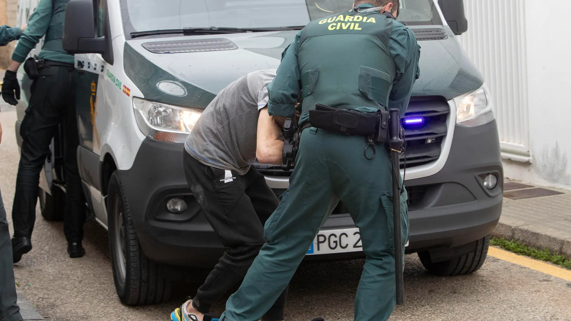 Agentes de la Guardia Civil trasladan a los juzgados de Barbate a uno de los ocho detenidos por la muerte de dos guardias civile