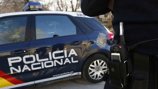 Un agente y un coche patrulla de la Policía Nacional. Un agente y un coche patrulla de la Policía Nacional.