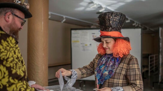 Una persona disfrazada vota en un colegio electoral en Xinzo de Limia (Ourense), este 18F.