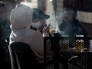 Una persona fumando en una terraza, a 27 de diciembre de 2023, en Madrid (España).