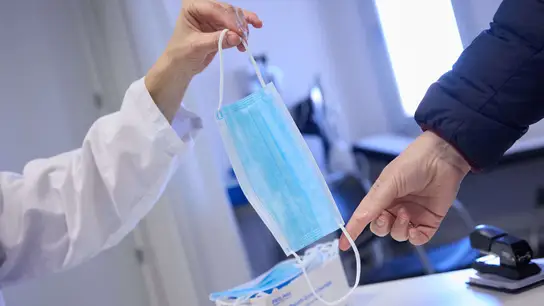 Una sanitaria ofrece una mascarilla a un paciente en el centro de salud 'Isla de Oza', a 11 de enero de 2024, en Madrid (España). Una sanitaria ofrece una mascarilla a un paciente en el centro de salud 'Isla de Oza', a 11 de enero de 2024, en Madrid (España).