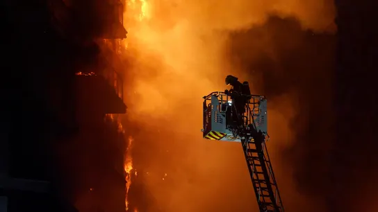Un bombero trata de apagar el edificio en llamas con dos personas en un balcón, en el barrio de Campanar, a 22 de febrero de 2024, en Valencia Un bombero trata de apagar el edificio en llamas con dos personas en un balcón, en el barrio de Campanar, a 22 de febrero de 2024, en Valencia