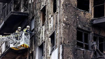 Bomberos en una grúa sanean la fachada del edificio incendiado en Campanar, Valencia