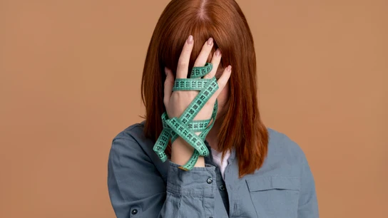 Una chica con un metro en la mano representando a un trastorno de alimentación. Una chica con un metro en la mano representando a un trastorno de alimentación.