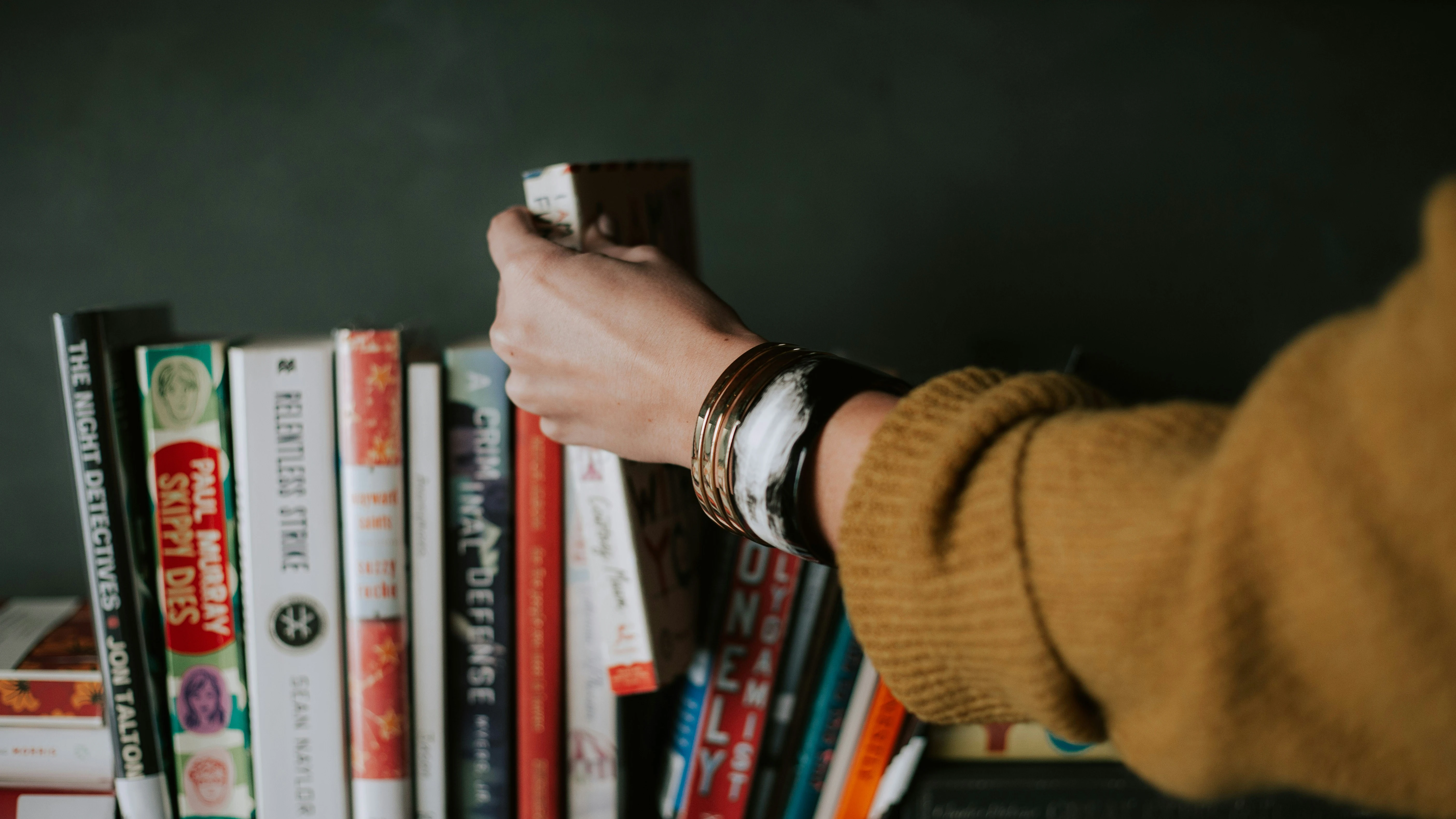 Una mujer escoge entre varios libros.