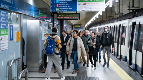 Un grupo de personas sin mascarilla en el and&eacute;n de la estaci&oacute;n de Metro de Plaza de Castilla.