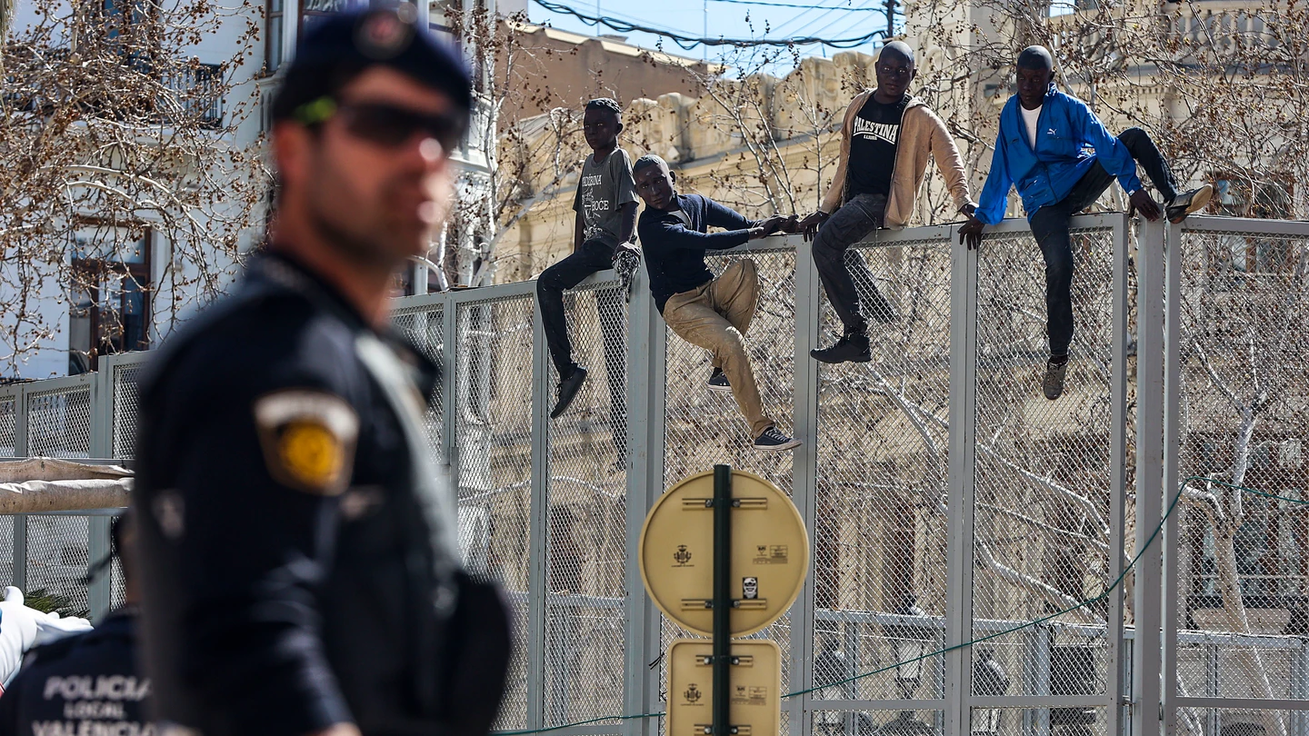 Simulación de cuatro migrantes saltando la Valla de Melilla, en la Plaza del Ayuntamiento de Valencia Simulación de cuatro migrantes saltando la Valla de Melilla, en la Plaza del Ayuntamiento de Valencia