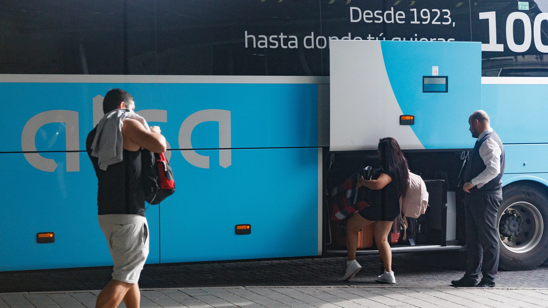Viajeros depositando sus maletas en el maletero de un autobús en la Estación Sur de Méndez Álvaro, a 28 de abril de 2023, en Madrid (España).