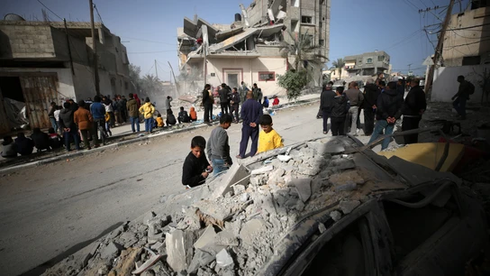 Palestinos alrededor de un edificio destruido por un bombardeo israelí en Rafah, Gaza Palestinos alrededor de un edificio destruido por un bombardeo israelí en Rafah, Gaza