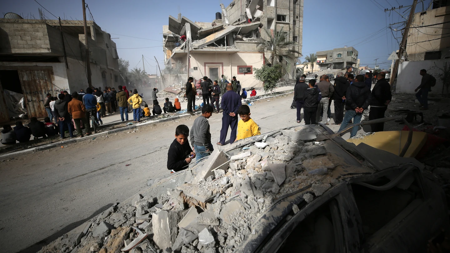 Palestinos alrededor de un edificio destruido por un bombardeo israelí en Rafah, Gaza Palestinos alrededor de un edificio destruido por un bombardeo israelí en Rafah, Gaza