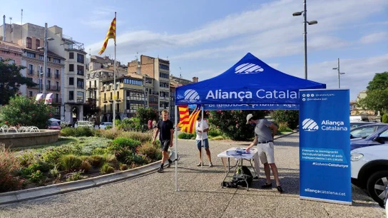 Un puesto de Aliança Catalana en la Plaça Catalunya de Girona en 2024 Un puesto de Aliança Catalana en la Plaça Catalunya de Girona en 2024
