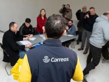 Un trabajador de Correos lleva los votos realizados por correo a la mesa electoral, en el Centro Galego de Arte Contempor&aacute;neo.