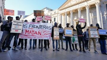 Manifestantes ante el Congreso de los Diputados este martes con motivo de la votación a la iniciativa legislativa popular que regulará la situación de medio millón de migrantes en España.