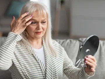 Mujer contemplando sus signos de envejecimiento Mujer contemplando sus signos de envejecimiento