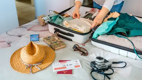 Mujer haciendo la maleta para irse de crucero Mujer haciendo la maleta para irse de crucero