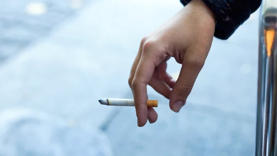 Una persona fumando un cigarrillo. Una persona fumando un cigarrillo.
