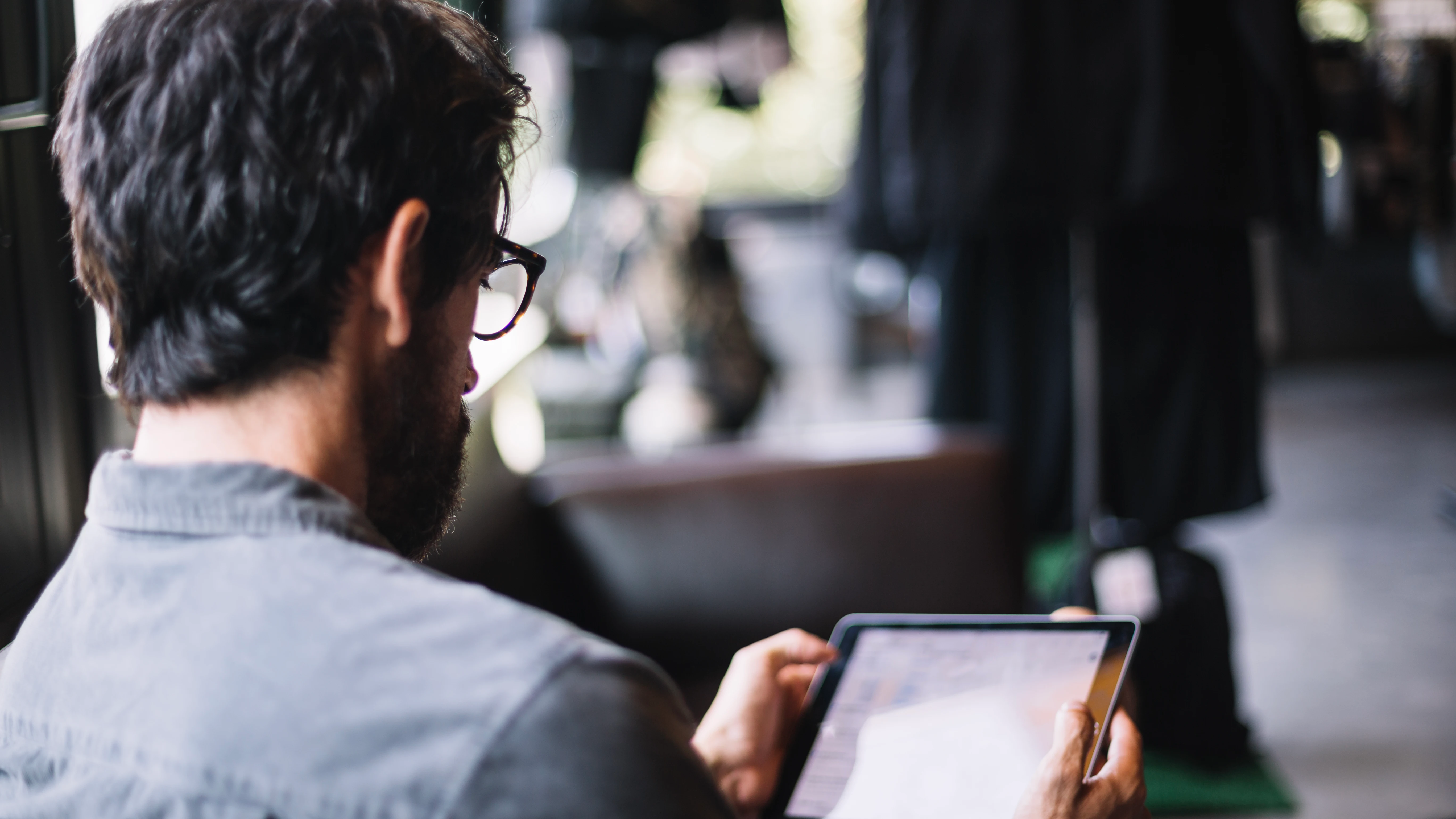 Un hombre leyendo en una tablet. 