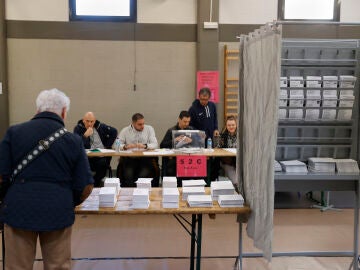 Un hombre escoge papeleta para ejercer su derecho al voto en las elecciones vascas de 2024