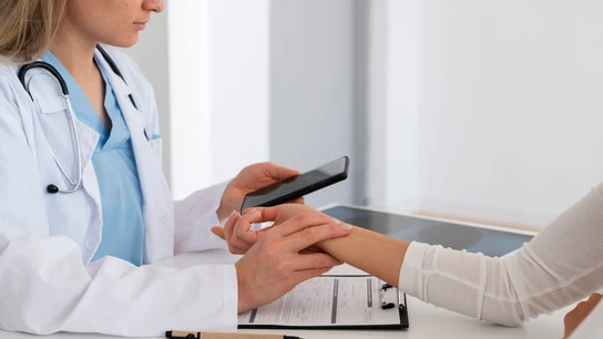 Una médica tratando a una paciente en su consulta de medicina.  Una médica tratando a una paciente en su consulta de medicina.