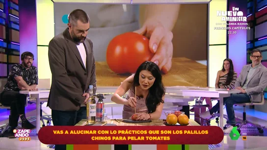 Jiaping muestra una práctica técnica para pelar un tomate con palillos chinos Jiaping muestra una práctica técnica para pelar un tomate con palillos chinos