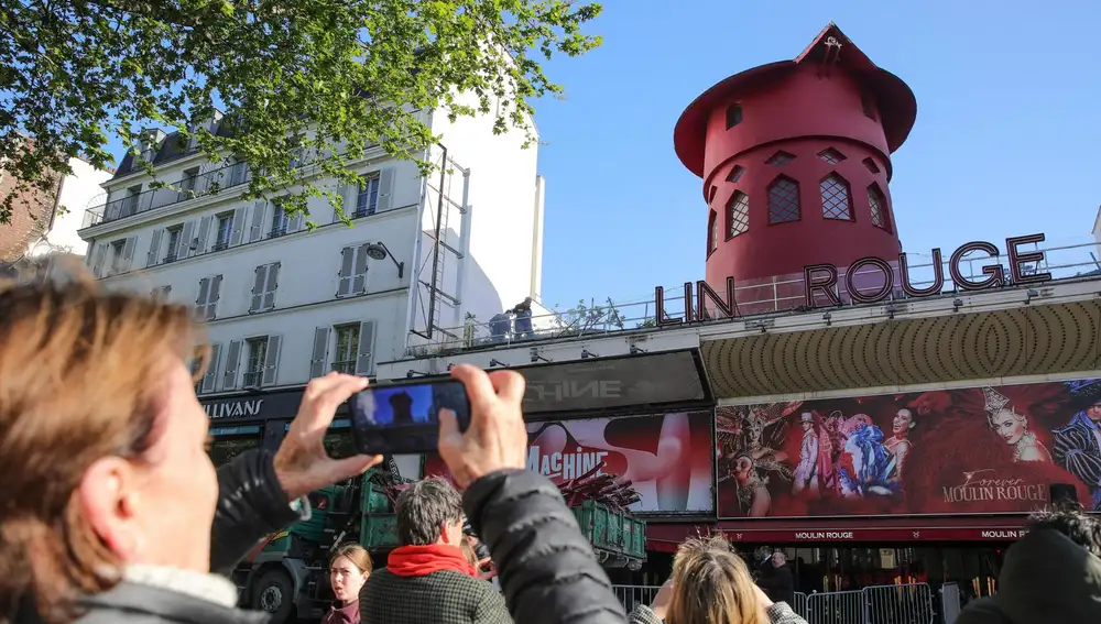 Turista viendo el Moulin Rouge de París sin aspas