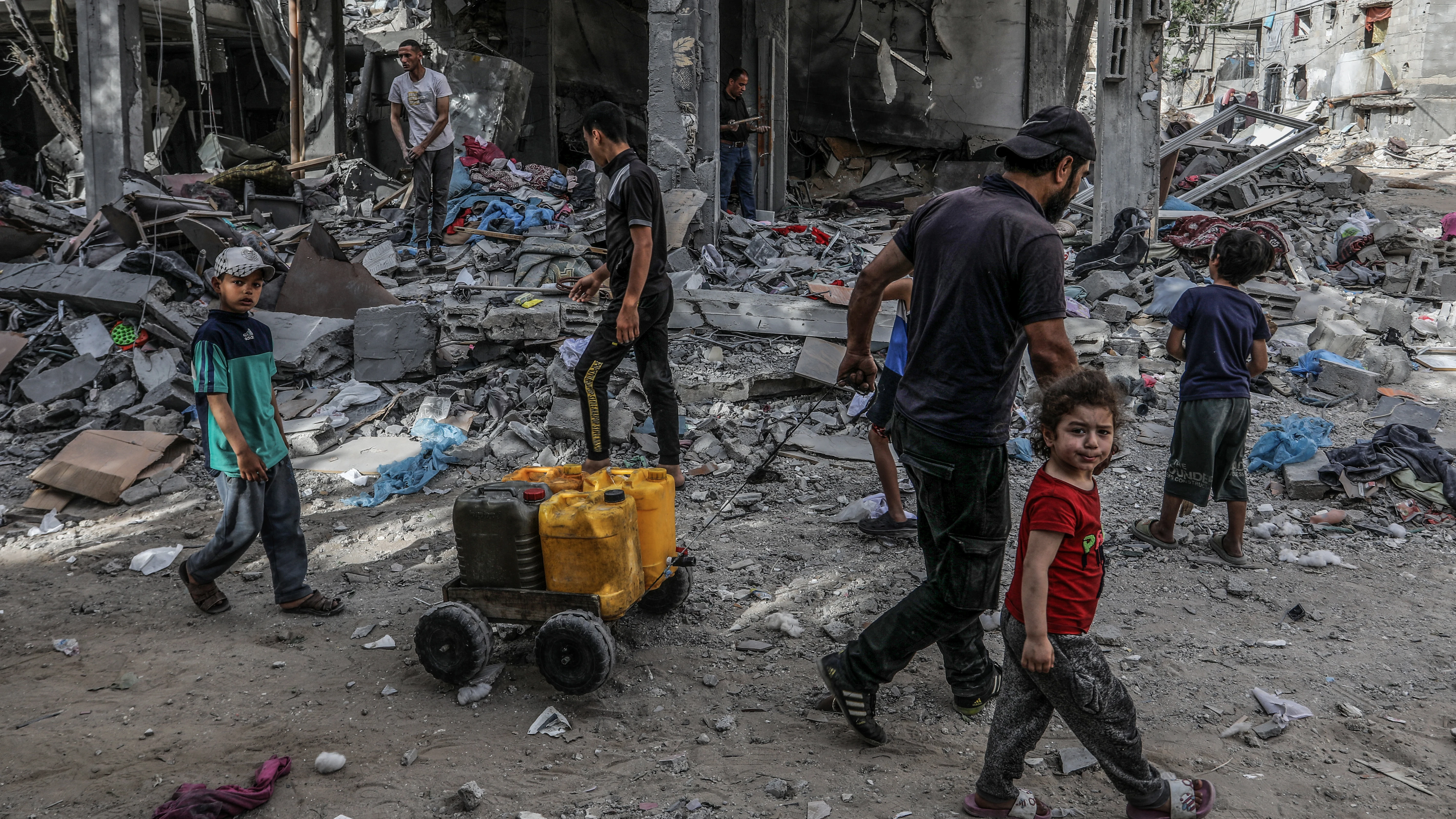 Refugiados palestinos caminan entre los escombros en Rafah Refugiados palestinos caminan entre los escombros en Rafah