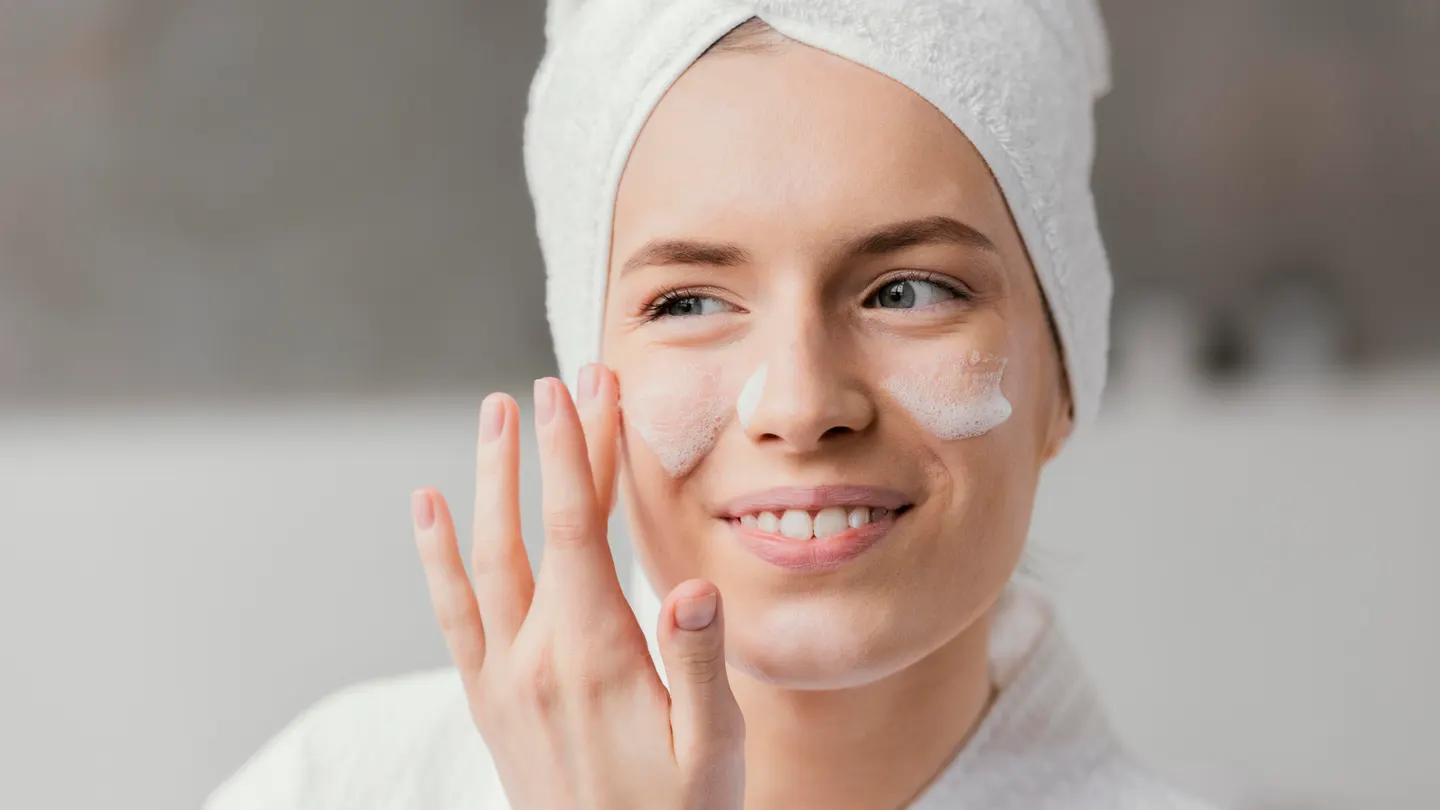 Una joven realizando su limpieza facial o rutina 'skincare' Una joven realizando su limpieza facial o rutina 'skincare'