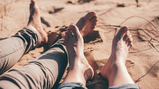 Una pareja descansa sin zapatos en un ambiente caluroso. Una pareja descansa sin zapatos en un ambiente caluroso.