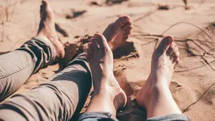 Una pareja descansa sin zapatos en un ambiente caluroso.