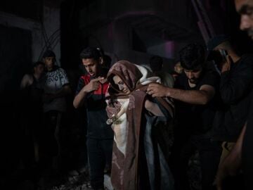 Una mujer es rescatada de los escombros de un edificio derruido tras un bombardeo israelí en Gaza