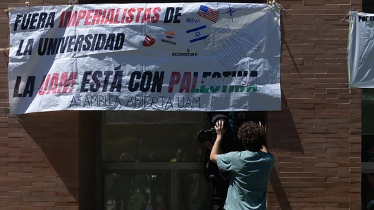 Un estudiante pone una pancarta durante una acampada. Un estudiante pone una pancarta durante una acampada.