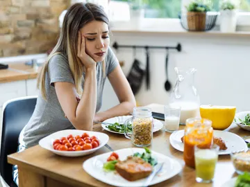 Una chica joven que mira con disgusto la comida Una chica joven que mira con disgusto la comida