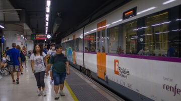 Viajeros al lado de un tren en uno de los andenes de la estación de Sants.