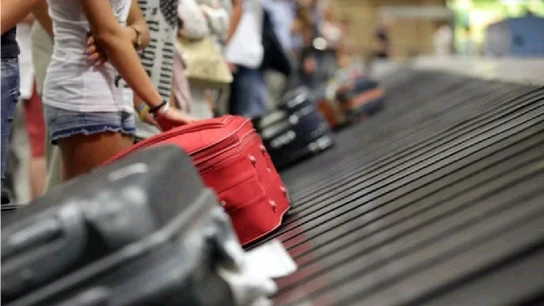 Turistas recogiendo maletas en un aeropuerto cifras