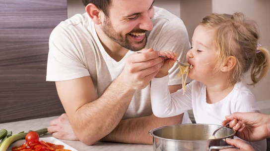 Un padre con su hija comiendo.  Los padres deben dar ejemplo a sus hijos con la alimentación.
