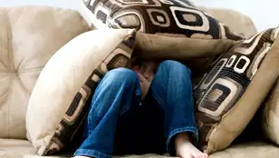 Un niño preocupado, rodeado de almohadas