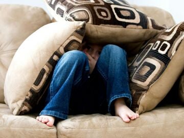 Un niño preocupado, rodeado de almohadas