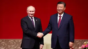 El presidente de Rusia, Vladimir Putin (izq.), y el presidente de China, Xi Jinping, se dan la mano durante un concierto con motivo del 75º aniversario del establecimiento de relaciones diplomáticas entre Rusia y China y la inauguración de los Años de Cultura China-Rusia en el Centro Nacional de Artes Escénicas. 