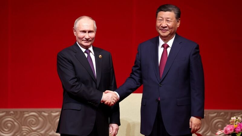 El presidente de Rusia, Vladimir Putin (izq.), y el presidente de China, Xi Jinping, se dan la mano durante un concierto con motivo del 75º aniversario del establecimiento de relaciones diplomáticas entre Rusia y China y la inauguración de los Años de Cultura China-Rusia en el Centro Nacional de Artes Escénicas. 