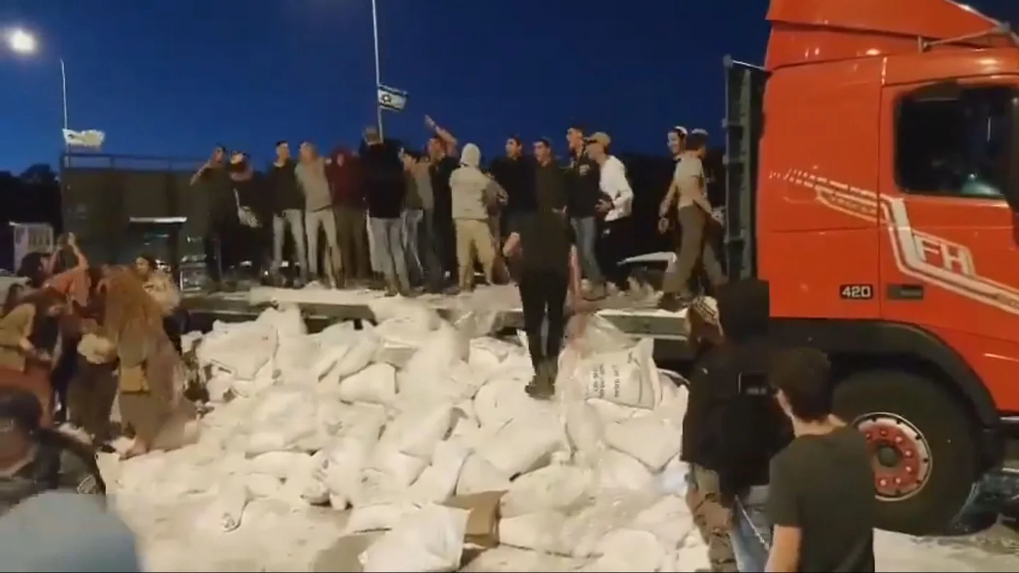 Colonos israelíes celebrando el saqueo a un camión de ayuda humanitaria en Cisjordania Colonos israelíes celebrando el saqueo a un camión de ayuda humanitaria en Cisjordania