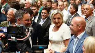 Santiago Abascal y Jorge Buxadé se dan la mano ante la mirada de Marine Le Pen