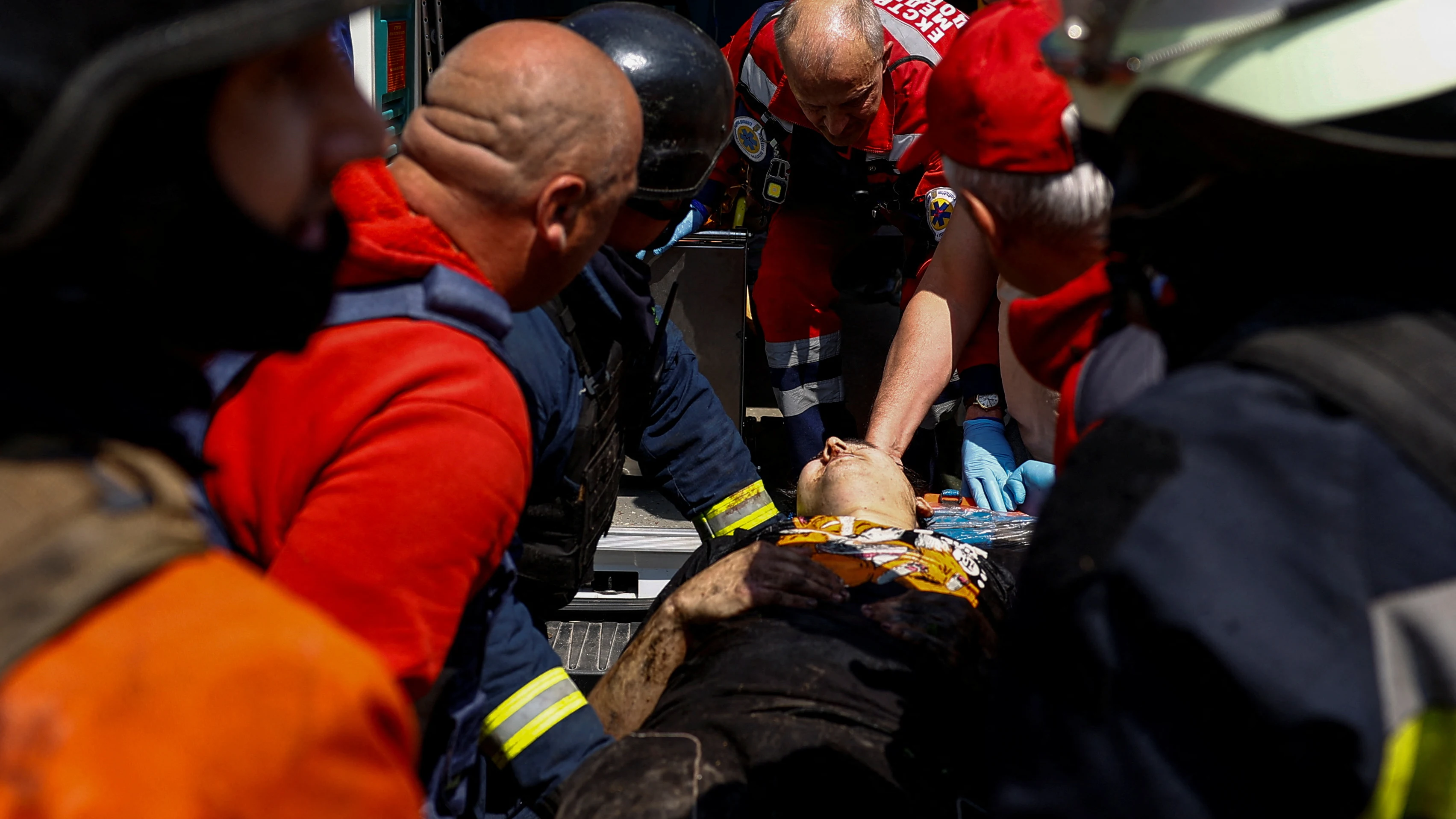 Trabajadores de emergencia llevan a una persona herida a una ambulancia en el lugar de una estructura turística alcanzada por un misil ruso, en medio del ataque de Rusia a Ucrania, en Járkiv, el 19 de mayo de 2024. 