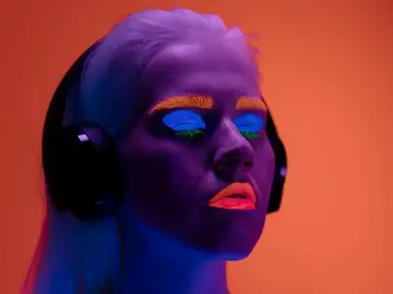 Mujer maquillada con colores flúor escuchando música Mujer maquillada con colores flúor escuchando música
