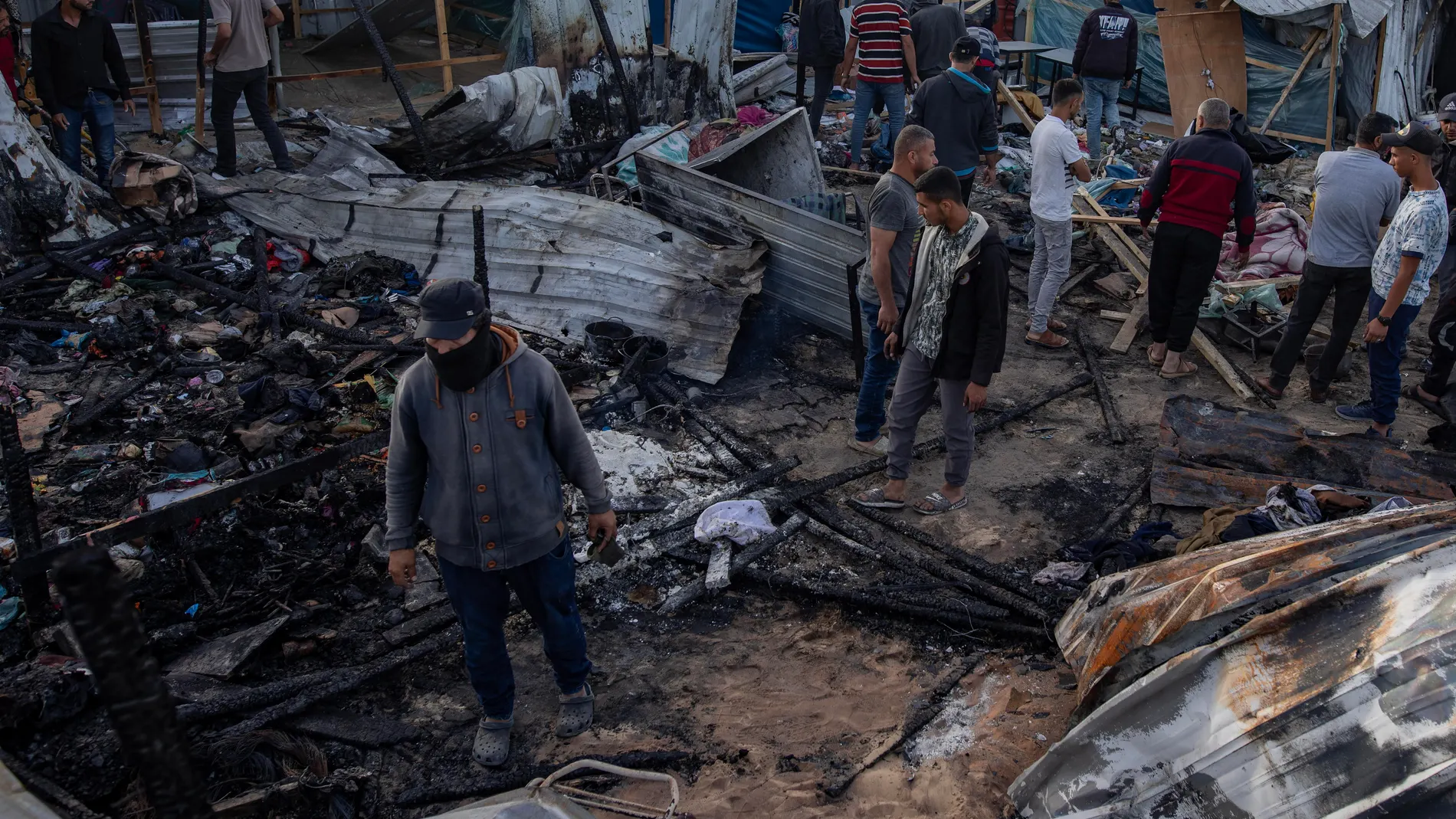 Palestinos revisando los daños tras el ataque israelí contra un campamento de desplazados en Rafah, en el sur de la Franja de Gaza, que ha dejado al menos 45 muertos según las autoridades gazatíes.